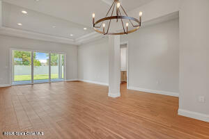 4195 Negal Circle Melbourne, FL 32901 - Photo 5 of 17 a view of an empty room with wooden floor and chandelier