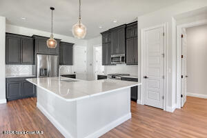4195 Negal Circle Melbourne, FL 32901 - Photo 9 of 17 a large white kitchen with a sink a refrigerator and a wooden floor