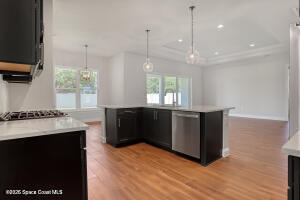 4195 Negal Circle Melbourne, FL 32901 - Photo 10 of 17 a kitchen with stainless steel appliances granite countertop a stove a sink and a wooden floors