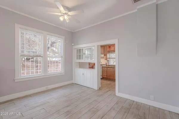 an empty room with wooden floor and windows