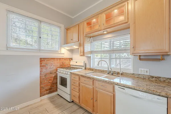 a kitchen with stainless steel appliances granite countertop a sink and a window
