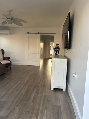 a view of a livingroom with wooden floor and a flat screen tv