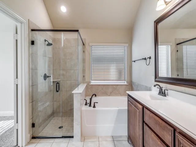 a bathroom with a bathtub shower sink and mirror