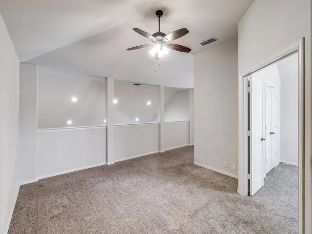 a view of an empty room with a ceiling fan
