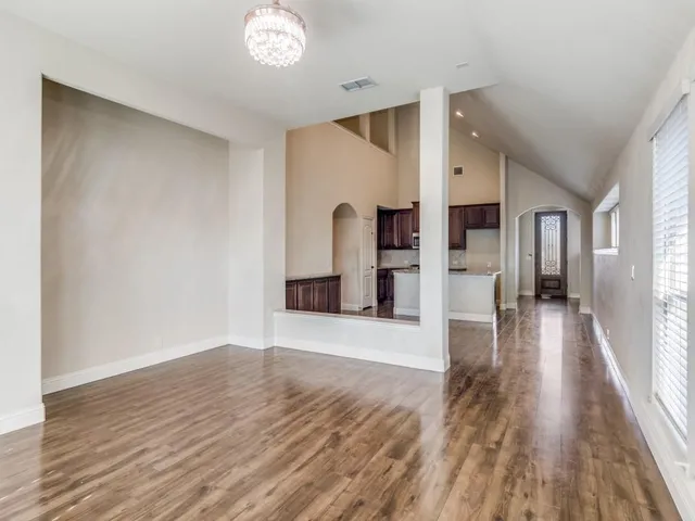 a view of a hallway with wooden floor and a living room