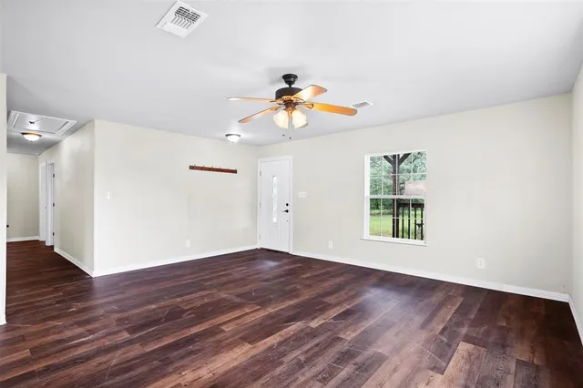 wooden floor in an empty room with a window