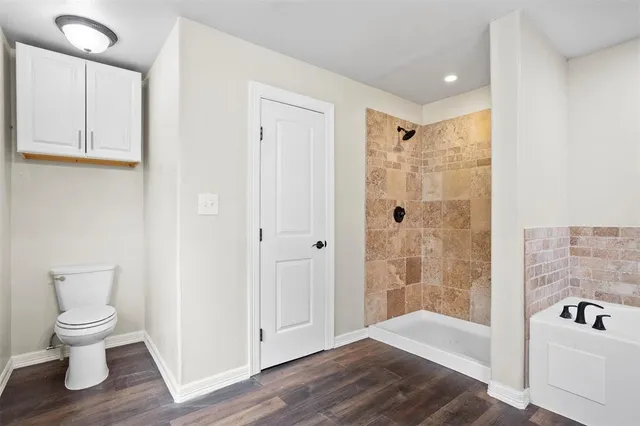 a bathroom with a shower a toilet and a sink