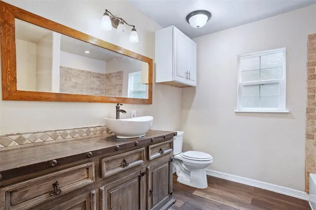 a bathroom with a granite countertop toilet a sink and a mirror