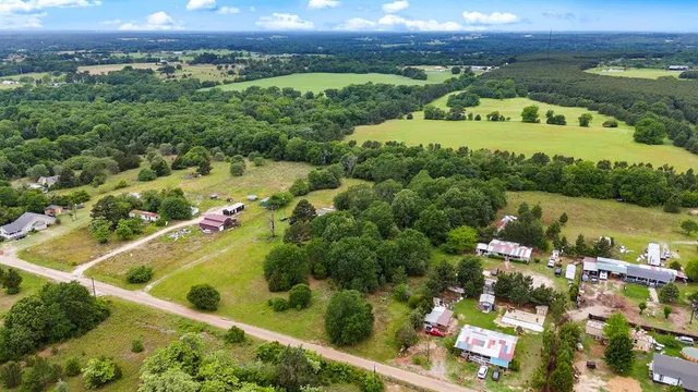 an aerial view of a houses with a yard and lake view
