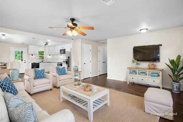 a living room with furniture a flat screen tv and a window