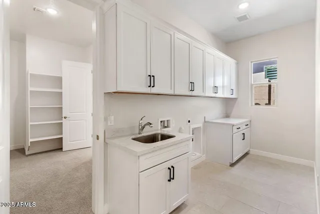 a kitchen with white cabinets and a sink