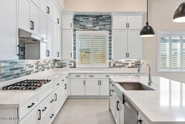 a kitchen with granite countertop a sink stove and cabinets