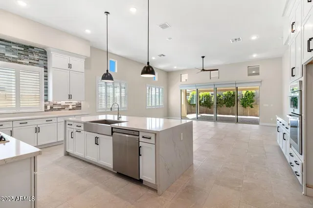 a large kitchen with stainless steel appliances granite countertop a stove and a sink