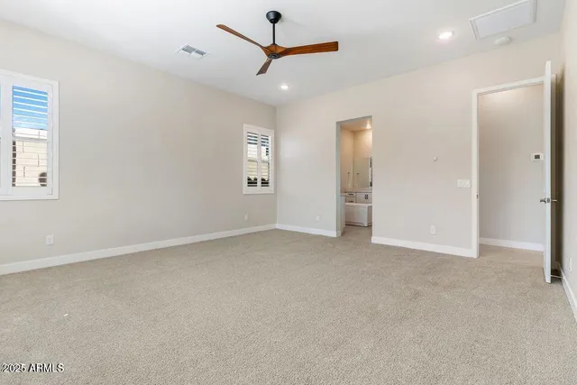 an empty room with closet and a ceiling fan
