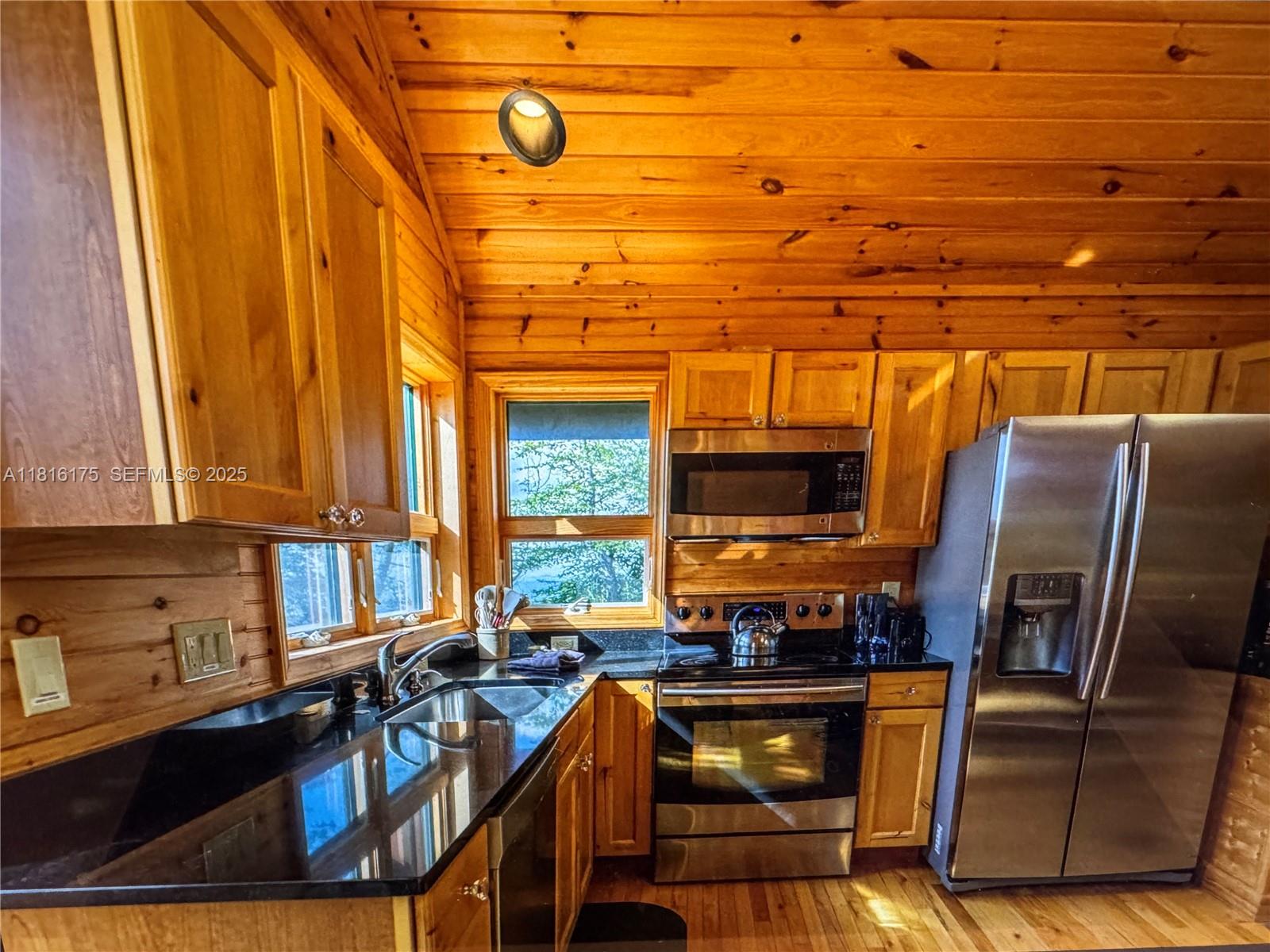 200 Summit Lodge Road Banner Elk, NC 28604 - Photo 40 of 51 a kitchen with stainless steel appliances wooden cabinets a stove a sink and a microwave