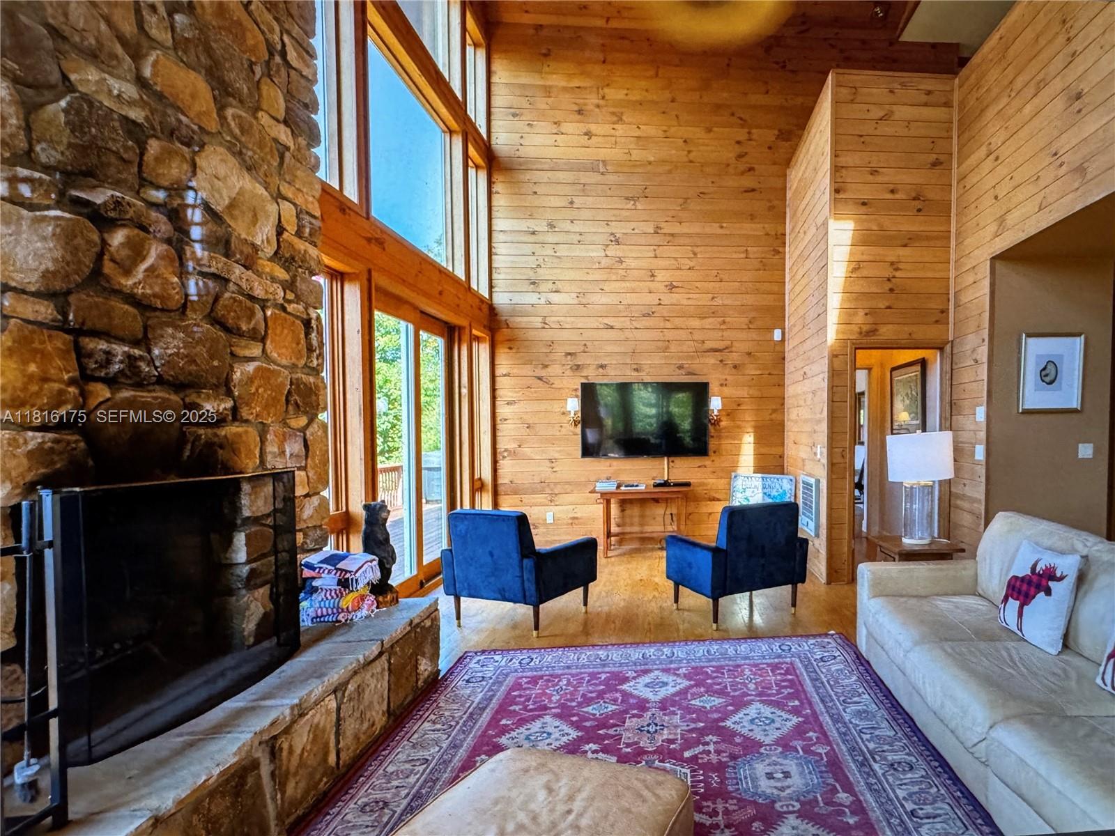 200 Summit Lodge Road Banner Elk, NC 28604 - Photo 6 of 51 a living room with furniture a flat screen tv and a fireplace