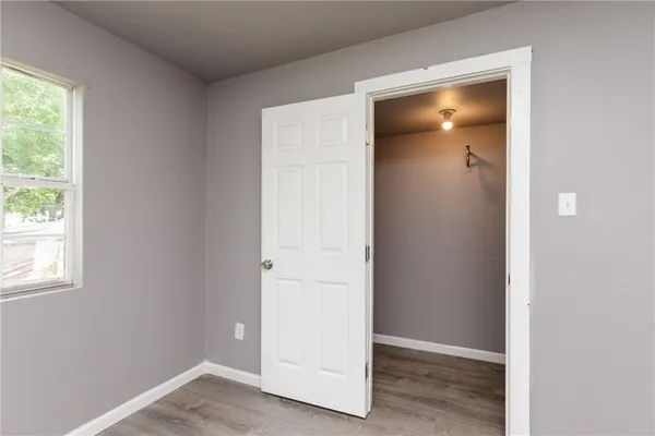 an empty room with windows and closet