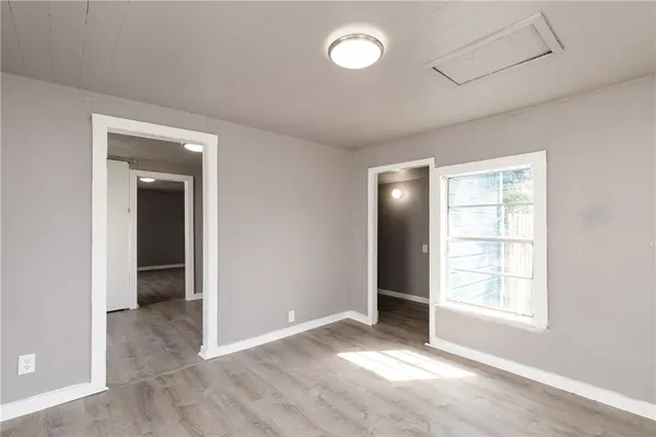 a view of an empty room with closet and a window