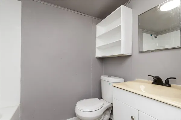 a bathroom with a toilet a sink and mirror