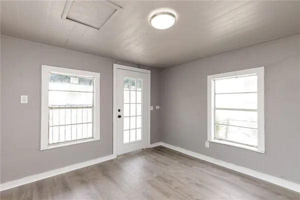 an empty room with wooden floor and windows