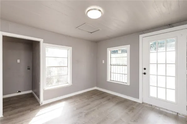 an empty room with wooden floor and windows