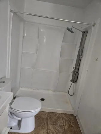 a bathroom with a shower a toilet and a shower