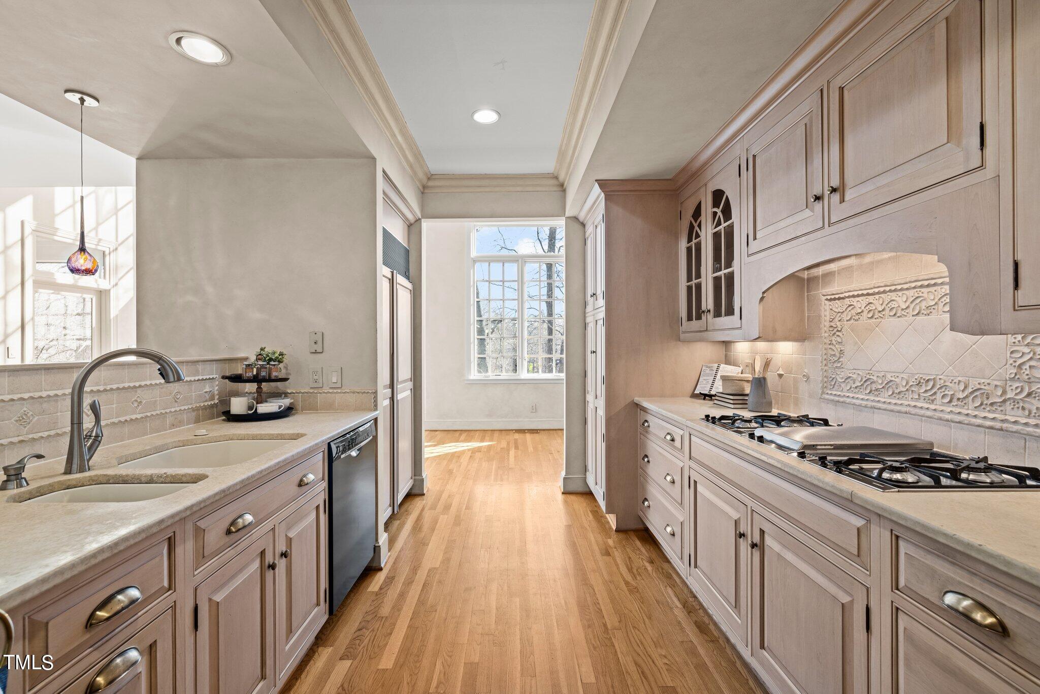 202 Villa Drive Durham, NC 27712 - Photo 29 of 53 a kitchen with stainless steel appliances a sink dishwasher stove and white cabinets with wooden floor