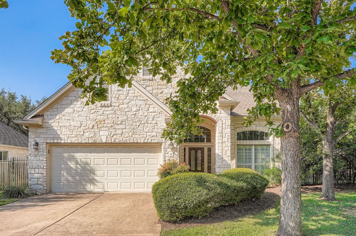 View of front of house featuring stone siding, driveway, and an attached 2 car garage w one door