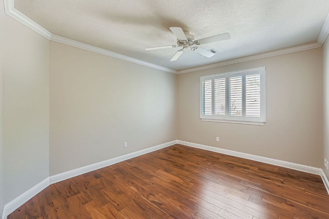 5000 Mission Oaks Boulevard, Unit 61 Austin, TX 78735 - Photo 17 of 27 Spare room with dark wood-style floors, ornamental molding, a textured ceiling, and ceiling fan