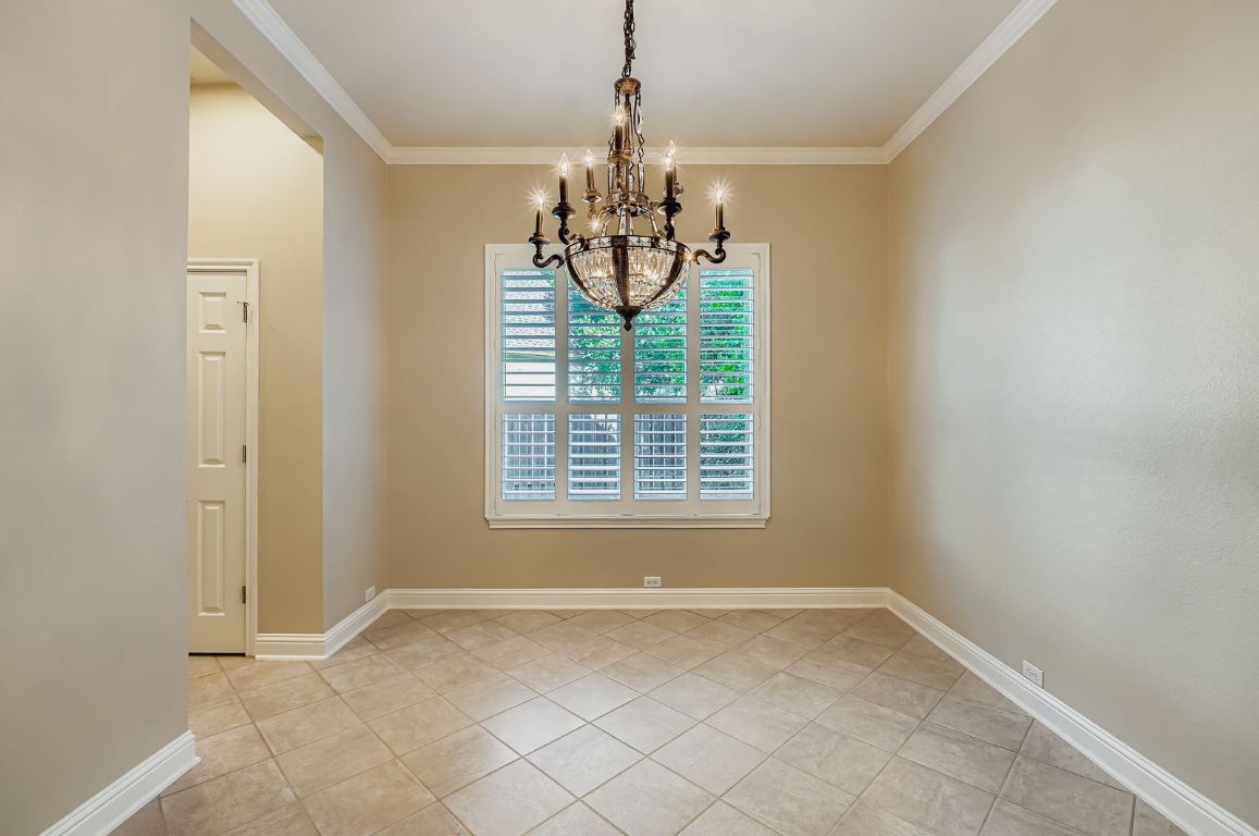 5000 Mission Oaks Boulevard, Unit 61 Austin, TX 78735 - Photo 5 of 27 dining area with crown molding, light tile patterned floors, and a chandelier