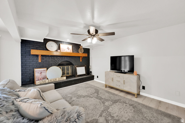 5057 South Ridgedale Drive Ogden, UT 84403 - Photo 37 of 69 Living area featuring a black brick fireplace with an arched firebox opening and a wood mantel