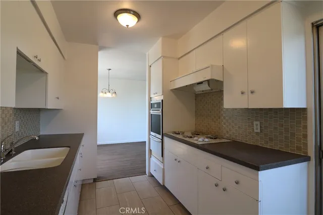 a kitchen with granite countertop a sink and a stove