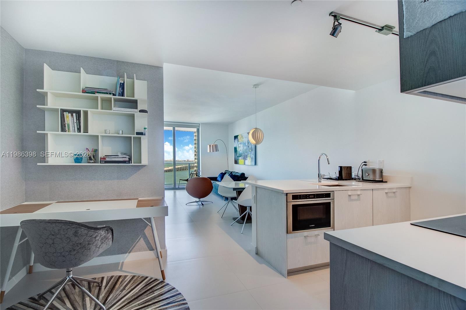 501 Northeast 31st Street, Unit 1502 Miami, FL 33137 - Photo 6 of 12 a living room with stainless steel appliances furniture a rug and white cabinets