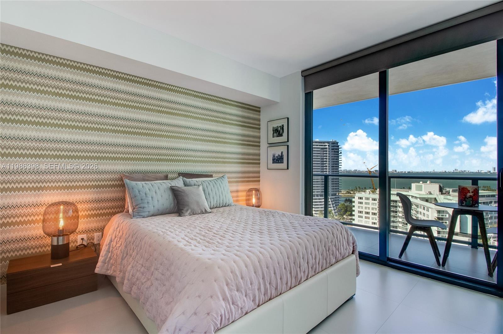 501 Northeast 31st Street, Unit 1502 Miami, FL 33137 - Photo 7 of 12 a bedroom with a large bed and a balcony view