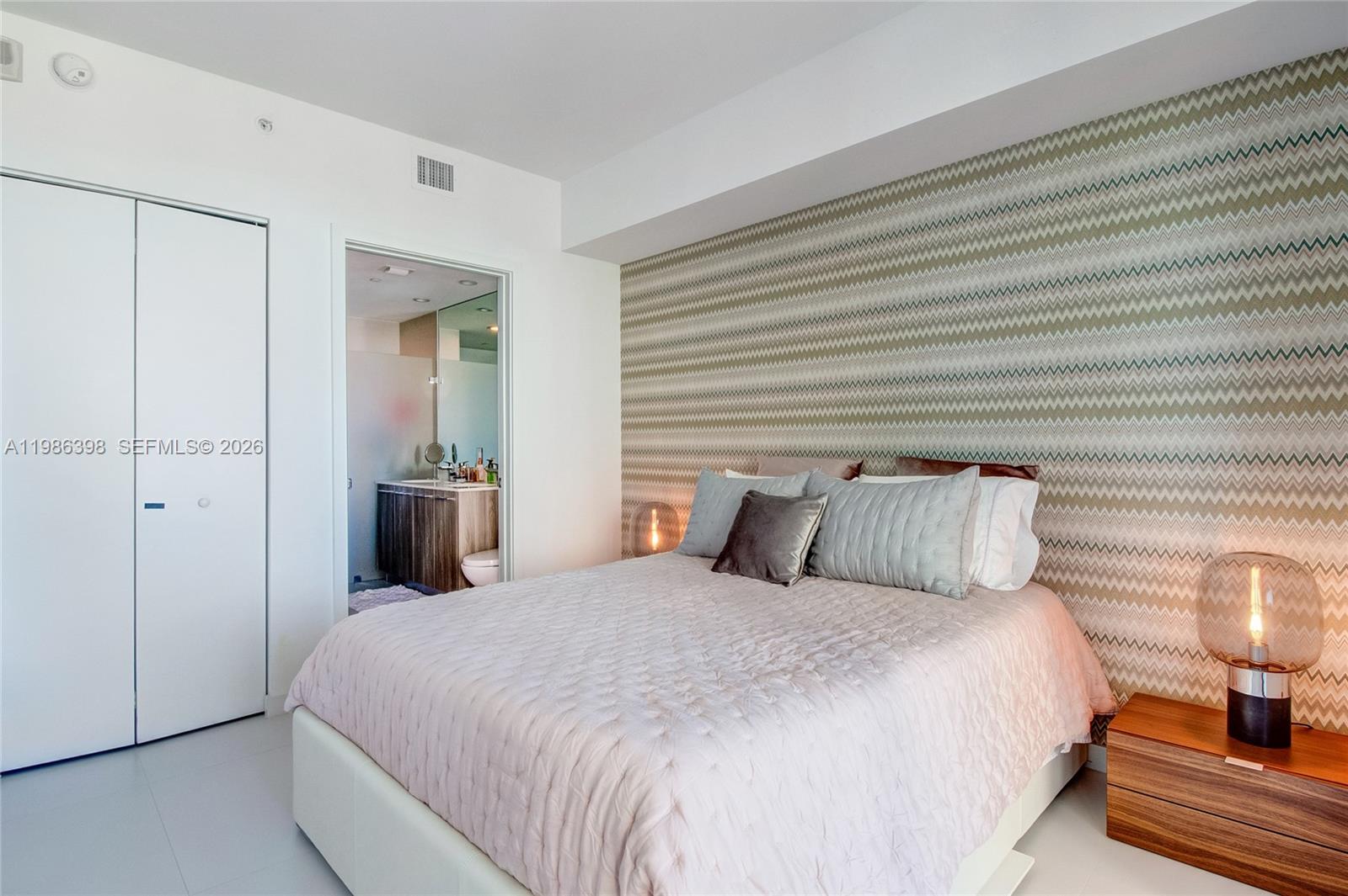 501 Northeast 31st Street, Unit 1502 Miami, FL 33137 - Photo 8 of 12 a bedroom with a bed and a lamp