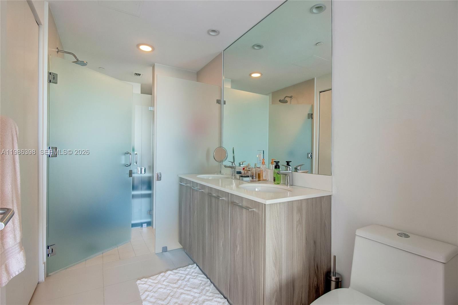 501 Northeast 31st Street, Unit 1502 Miami, FL 33137 - Photo 9 of 12 a bathroom with a sink a toilet a shower and a mirror