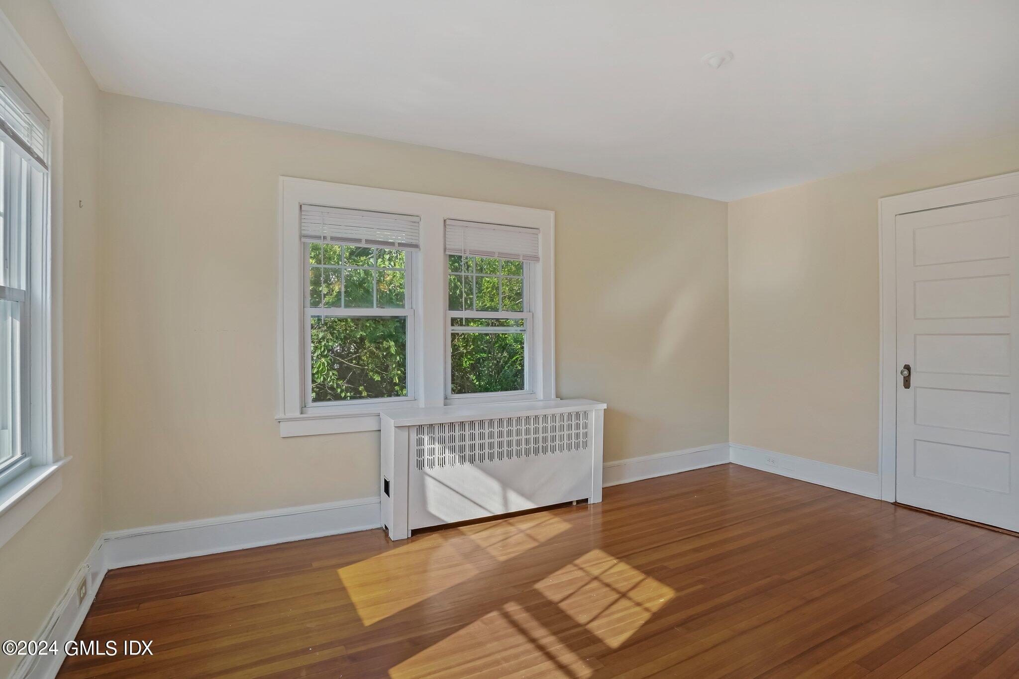 8 Sheep Hill Road, Unit TOP Riverside, CT 06878 - Photo 8 of 11 a view of an empty room with wooden floor and a window