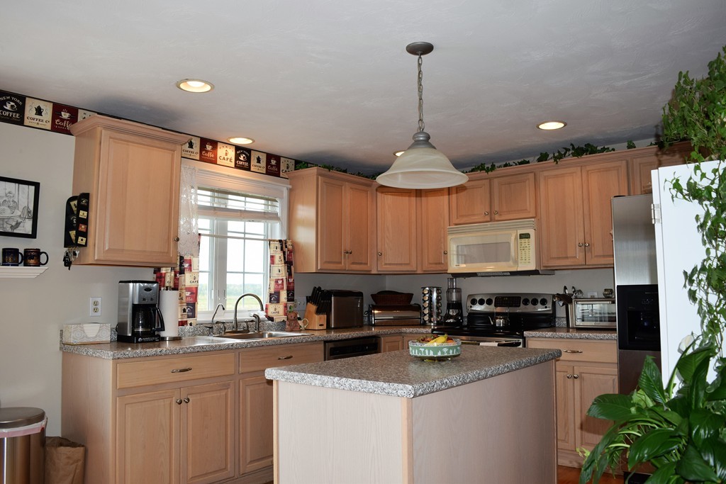 102 Howland Road Freetown, MA 02702 - Photo 4 of 30 a kitchen with stainless steel appliances granite countertop a sink a stove a refrigerator a center island and cabinets
