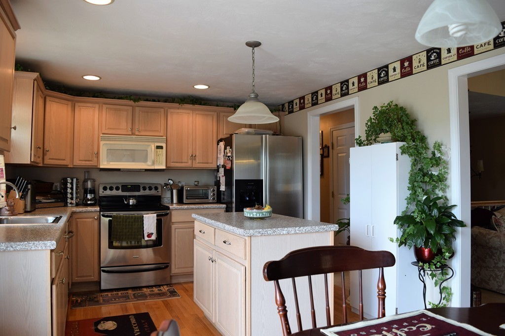 102 Howland Road Freetown, MA 02702 - Photo 5 of 30 a kitchen with stainless steel appliances granite countertop a stove a refrigerator and a microwave