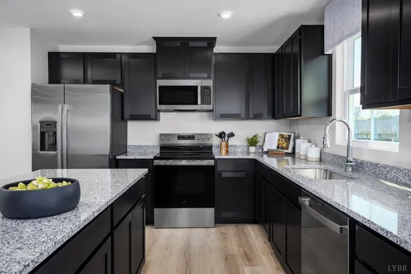 a kitchen with stainless steel appliances granite countertop a sink a stove and refrigerator