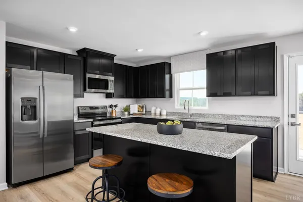 a kitchen with granite countertop stainless steel appliances a sink dishwasher a refrigerator a stove a microwave and wooden cabinets