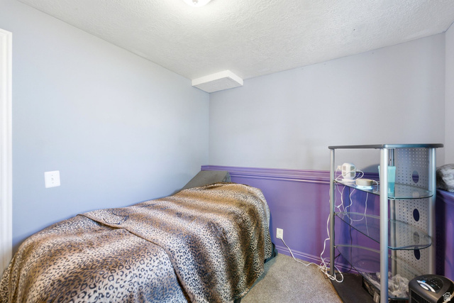 2475 Church Street Layton, UT 84040 - Photo 15 of 27 Compact room featuring a textured ceiling and light-toned walls with a purple wainscoting accent