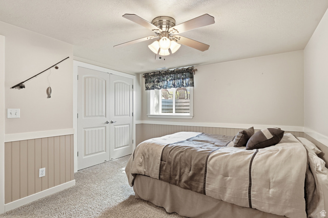 2420 West Old Hwy Road Morgan, UT 84050 - Photo 36 of 54 Carpeted bedroom with a wainscoted wall, a closet, ceiling fan, and a textured ceiling