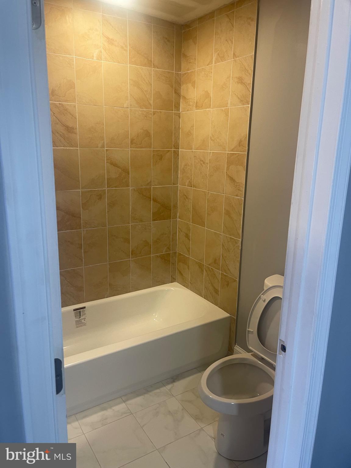 5618 Appletree Street, Unit 2 Philadelphia, PA 19139 - Photo 9 of 11 a bathroom with a granite countertop bathtub and a sink