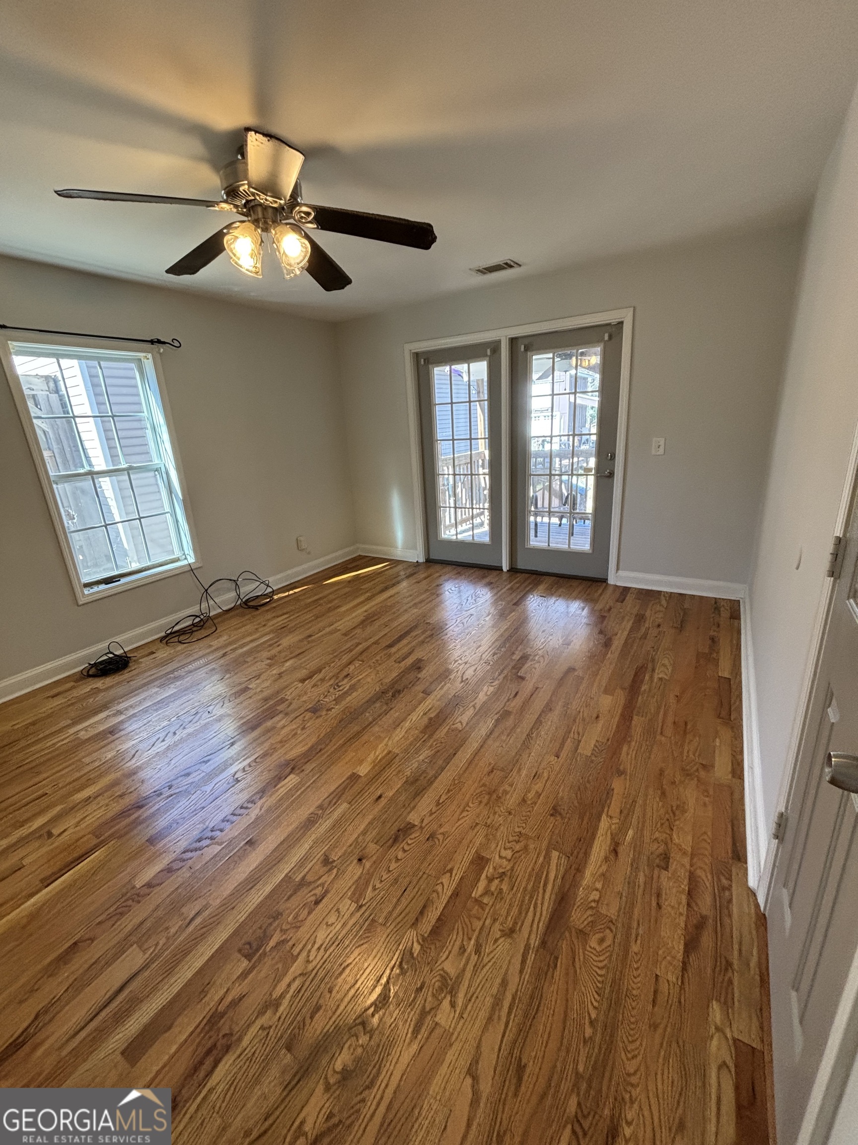 88 East Washington Street Newnan, GA 30263 - Photo 3 of 9 a view of an empty room with wooden floor and a window