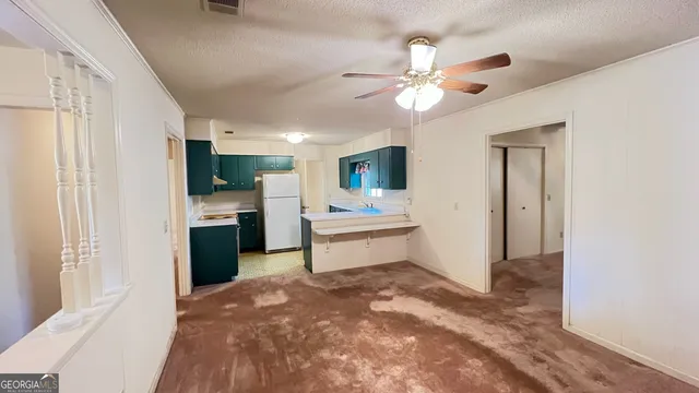 a large white kitchen with a sink and dishwasher a refrigerator with wooden floor