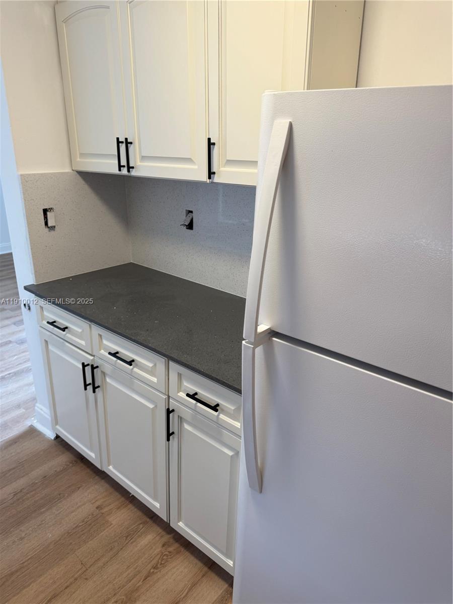 748 Northwest 77th Terrace, Unit 748 Miami, FL 33150 - Photo 3 of 3 a kitchen with white cabinets and white appliances