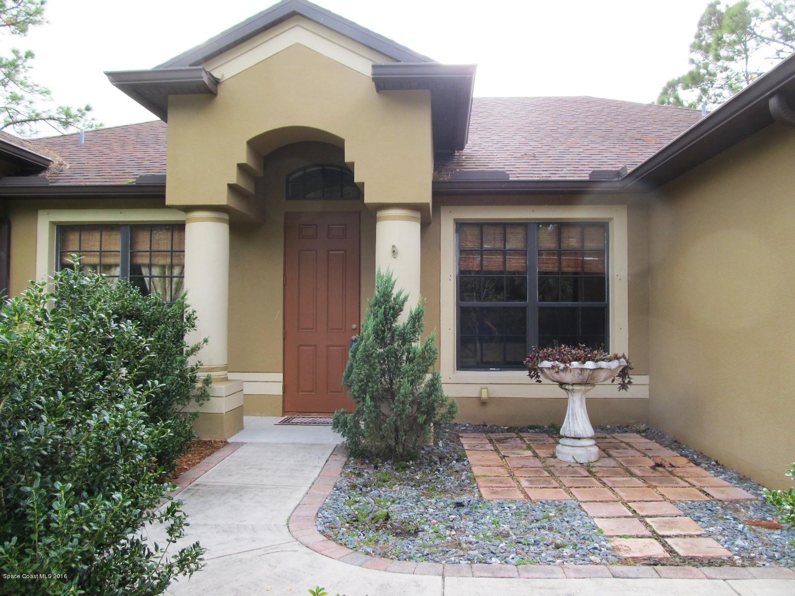 1140 Sexton Road Southwest Palm Bay, FL 32908 - Photo 2 of 20 a front view of a house with a yard