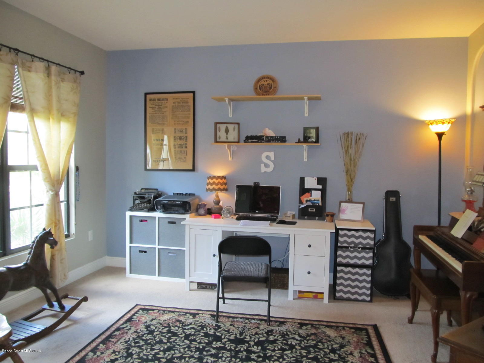 1140 Sexton Road Southwest Palm Bay, FL 32908 - Photo 4 of 20 a work room with furniture a flat screen tv and a window