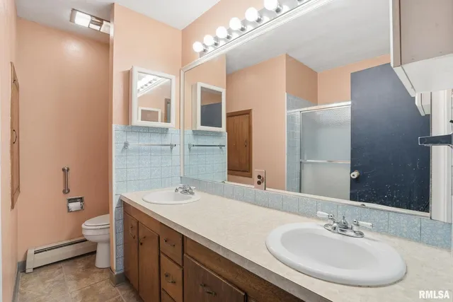a bathroom with a double vanity sink mirror and toilet